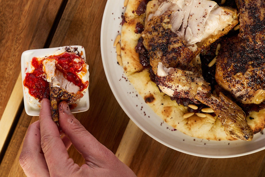 Musakhan chicken being dipped in yoghurt with Fil's Bird's Eye Shatta